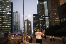A man takes a "selfie" at a street blocked by pro-democracy protesters outside the government headquarters office in Hong Kong