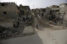 A man rides a motorbike near damaged buildings in the town of Marat Numan in Idlib province, Syria, Syria, March 19, 2016. PHOTO BY REUTERS/Khalil Ashawi