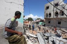 A Somali man watches the damage caused at the scene where a car exploded in the Madina district of Mogadishu, Somalia, May 17, 2017. PHOTO BY REUTERS/Feisal Omar