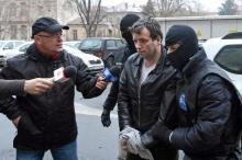 Marcel Lazar Lehel, 40, is escorted by masked policemen in Bucharest, after being arrested in Arad, 550 km (337 miles) west of Bucharest, January 22, 2014. PHOTO BY REUTERS/Mediafax/Silviu Matei