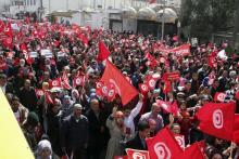 Tunisians wave their national flags during a march against extremism outside Tunis' Bardo, Museum, March 29, 2015. PHOTO BY REUTERS/Stringer