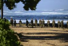 A group of Marines walk the beach outside the Haleiwa Incident Command Post in Haleiwa, Hawaii, during search efforts for 12 missing Marines, January 18, 2016. PHOTO BY REUTERS/U.S. Coast Guard