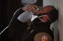 A civil defence member breathes through an oxygen mask, after what rescue workers described as a suspected gas attack in the town of Khan Sheikhoun in rebel-held Idlib, Syria, April 4, 2017. PHOTO BY REUTERS/Ammar Abdullah