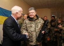 Ukrainian President Petro Poroshenko (R) shakes hands with U.S. Senator John McCain during a meeting with Ukrainian servicemen in Shirokino settlement near Mariupol, Ukraine, December 31, 2016. PHOTO BY REUTERS/Mikhail Palinchak