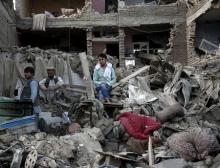 Men sit amid debris of their properties at the site a truck bomb blast in Kabul, August 7, 2015. PHOTO BY REUTERS/Ahmad Masood
