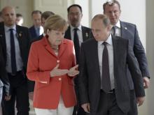 Russian President Vladimir Putin (R) and German Chancellor Angela Merkel walk during a meeting in Rio de Janeiro, July 13, 2014. PHOTO BY REUTERS/Alexey Nikolsky