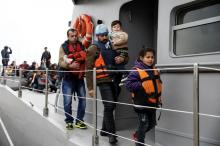 Refugees and migrants prepare to disembark a Greek Coast Guard vessel at the port of Mytilene on the Greek island of Lesbos, following a rescue operation at open sea, March 22, 2016. PHOTO BY REUTERS/Alkis Konstantinidis