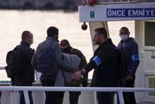 Frontex officers (R) guide migrants boarding a Turkish-flagged passenger boat to be returned to Turkey, on the Greek island of Lesbos, April 4, 2016. PHOTO BY REUTERS/Giorgos Moutafis