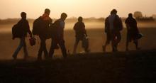 Migrants walk on a dirt road as they approach the Croatian border near the town of Sid, Serbia, September 18, 2015. PHOTO BY REUTERS/Stoyan Nenov