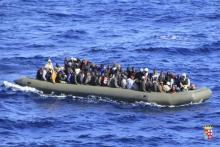 Migrants are seen in a boat during a rescue operation by Italian navy ship San Marco off the coast to the south of the Italian island of Sicily in this February 5, 2014 picture provided by the Italian Marina Militare.