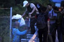 Immigrants from Syria cross a fence at Tabanovce near the Serbian border with Macedonia, June 19, 2015. PHOTO BY REUTERS/Ognen Teofilovski