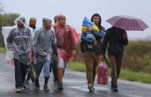 Migrant walk through the rain from Roszke to Szeged in Hungary, September 10, 2015. PHOTO BY REUTERS/Laszlo Balogh