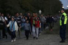 A police officer watches as migrants make their way through the border from Hungary towards the Austrian town of Nickelsdorf, September 21, 2015. PHOTO BY REUTERS/David W Cerny