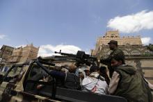 Shi'ite Houthi militants patrol the vicinity of a venue where a mass funeral for victims of a suicide attack on followers of the Shi'ite Houthi group was being held in Sanaa