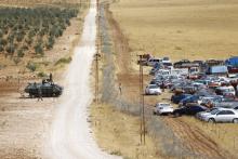 A Turkish military vehicle stands next to the Turkish-Syrian border as Kurdish Syrian refugees gather at the border fence, near the southeastern town of Suruc in Sanliurfa province, September 25, 2014. PHOTO BY REUTERS/Murad Sezer