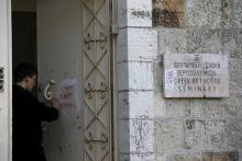 An Orthodox monk cleans graffiti from a door of the Greek Orthodox Seminary, located next to the Domition Abbey on Mount Zion in Jerusalem's Old City, January 17, 2016. PHOTO BY REUTERS/Ronen Zvulun