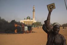 A man holds a copy of the Koran during a protest against Niger President Mahamadou Issoufou's attendance last week at a Paris rally in support of French satirical weekly Charlie Hebdo, which featured a cartoon of the Prophet Mohammad as the cover of its first edition since an attack by Islamist gunmen, in Niamey January 17, 2015. PHOTO BY REUTERS/Tagaza Djibo