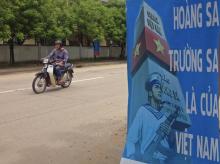 A man rides a motorcycle past a poster promoting Vietnam' sovereignty in the East Sea (South China Sea) on Phu Quoc island, September 11, 2014. PHOTO BY REUTERS/Martin Petty