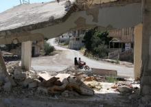People ride a motorbike past a damaged building in a rebel-held part of the southern city of Deraa, Syria, June 15, 2017. PHOTO BY REUTERS/Alaa Al-Faqir