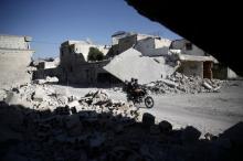 Men ride a motorcycle near damaged buildings in the rebel held Douma neighbourhood of Damascus, Syria, September 22, 2016. PHOTO BY REUTERS/Bassam Khabieh