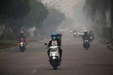 Motorists ride their motorbikes through haze due to a forest fire in Palangka Raya, Central Kalimantan province, Indonesia, September 15, 2019. PHOTO BY REUTERS/Willy Kurniawan