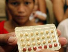 An NGO health worker holds contraceptive pills during a family planning session with housewives availing free pills in Tondo, Manila, August 6, 2012. PHOTO BY REUTERS/Erik De Castro