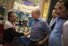 Israel's Economy Minister Naftali Bennett (R), head of the far-right Jewish Home party, shakes hands with a Russian-speaking immigrant as he campaigns in the southern city of Ashkelon, February 3, 2015. PHOTO BY REUTERS/Amir Cohen