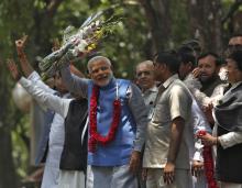 Hindu nationalist Narendra Modi (wearing a garland), the prime ministerial candidate for India's Bharatiya Janata Party (BJP), gestures to his supporters outside party's headquarters in New Delhi