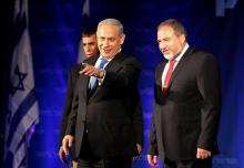 Israel's Prime Minister Benjamin Netanyahu (C) and former foreign minister and head of the Yisrael Beitenu party Avigdor Lieberman (R) look at supporters at the Likud-Yisrael Beitenu headquarters in Tel Aviv, January 23, 2013. PHOTO BY REUTERS/Nir Elias