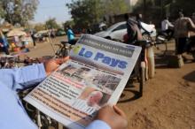 A man reads newspaper headlines that talk about the al Qaeda attack on the Splendid Hotel and Cappuccino that killed at least 28 people from at least seven countries in Ouagadougou, Burkina Faso, January 18, 2016. PHOTO BY REUTERS/Joe Penney