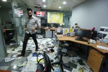 An employee walks on newspapers after protesters attacked the office of Saudi-owned newspaper Asharq al-Awsat in Beirut, Lebanon, April 1, 2016. PHOTO BY REUTERS/Mohamed Azakir