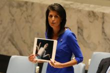 U.S. Ambassador to the United Nations Nikki Haley holds photographs of victims during a meeting at the United Nations Security Council on Syria at the United Nations Headquarters in New York City, NY, U.S., April 5, 2017. PHOTO BY REUTERS/Shannon Stapleton