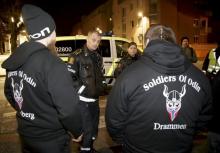 A policeman speaks to a member of anti-immigrant "Soldiers of Odin" in Drammen, Norway, in this February 21, 2016 file photo. PHOTO BY REUTERS/Heiko Junge/NTB Scanpix