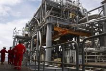 Oil workers walk through pipe installations on a tanker at Bonga off-shore oil field outside Lagos. PHOTO BY REUTERS