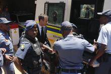 South African Olympic and Paralympic sprinter Oscar Pistorius (C) enters a police van after his sentencing at the North Gauteng High Court in Pretoria, October 21, 2014. PHOTO BY REUTERS/Siphiwe Sibeko