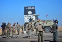 Shi'ite Popular Mobilization Forces (PMF) and Iraqi army members gather next to the black flag sign commonly used by Islamic State militants, on the outskirts of Hawija, Iraq, October 4, 2017. PHOTO BY REUTERS/Stringer