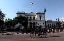A boy rides a bike in front of the parliament building in Cairo, June 14, 2012. PHOTO BY REUTERS/Mohamed Abd El-Ghany