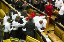Members of Julius Malema's Economic Freedom Fighters (EFF) (in red) clash with security officials after being ordered out of the chamber during President Jacob Zuma's State of the Nation address in parliament in Cape Town, February 12, 2015. PHOTO BY REUTERS/Roger Bosch