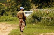 A UN peacekeeping force soldier patrols as he guards an area where severals wells containing the remains of massacred civilians were found, in Duekoue, west Ivory Coast, June 23, 2015. PHOTO BY REUTERS/Luc Gnago