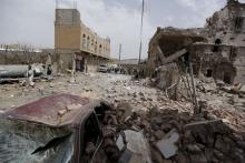 People walk past houses destroyed by a Saudi-led air strike in Sanaa, July 3, 2015. PHOTO BY REUTERS/Khaled Abdullah