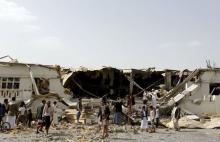 People gather outside a fabric factory after a Saudi-led air strike hit it in Yemen's capital Sanaa, July 10, 2015. PHOTO BY REUTERS/Khaled Abdullah