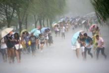 People hold umbrellas in heavy rain as Typhoon Soudelor approaches, in Hangzhou, Zhejiang province, August 7, 2015. PHOTO BY REUTERS/Stringer