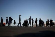 People are silhouetted as they wait to get on a ferry to Morocco, in front of the Rock of the British territory of Gibraltar (rear), at the southern Spanish port of Algeciras, July 31, 2015. PHOTO BY REUTERS/Jon Nazca