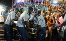 People look at an injured person being carried away after a carnival float hit power lines, on the second day of the annual Carnival celebrations in Haiti's capital Port-au-Prince in this February 17, 2015 still image taken from Reuters TV. PHOTO BY REUTERS/Reuters TV