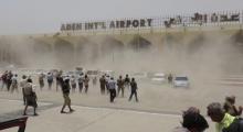 People seek cover from rising dust as a Qatari military cargo plane carrying aid lands at the international airport of Yemen's southern port city of Aden, August 1, 2015. PHOTO BY REUTERS/Stringer