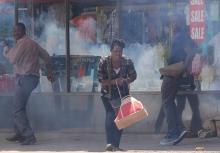 People flee teargas during clashes between police and street vendors in central Harare, Zimbabwe, September 27,2016. PHOTO BY REUTERS/Philimon Bulawayo