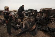 Kurdish Peshmerga fighters stand near burning vehicles during a suicide attack carried out by the Islamic State group in Kesarej village, south of Zumar, Nineveh province, December 18, 2014. REUTERS/Ari Jalal