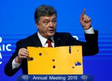 Ukrainian President Petro Poroshenko holds a fragment of a bus body which he says shows a Russian missile attack on a civilian bus as he addresses The Future of Ukraine event in the Swiss mountain resort of Davos, January 21, 2015. PHOTO BY REUTERS/Ruben Sprich