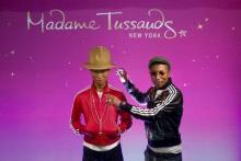 Musician Pharrell Williams poses next to his wax double at Madame Tussauds in New York, April 1, 2015. PHOTO BY REUTERS/Eduardo Munoz
