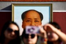People take pictures on Tiananmen Square as the portrait of China's late Chairman Mao Zedong is seen in the background in Beijing, China, on the 40th anniversary of his death, September 9, 2016. PHOTO BY REUTERS/Thomas Peter